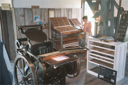 A photo of a printing workshop with various printmaking presses and tools