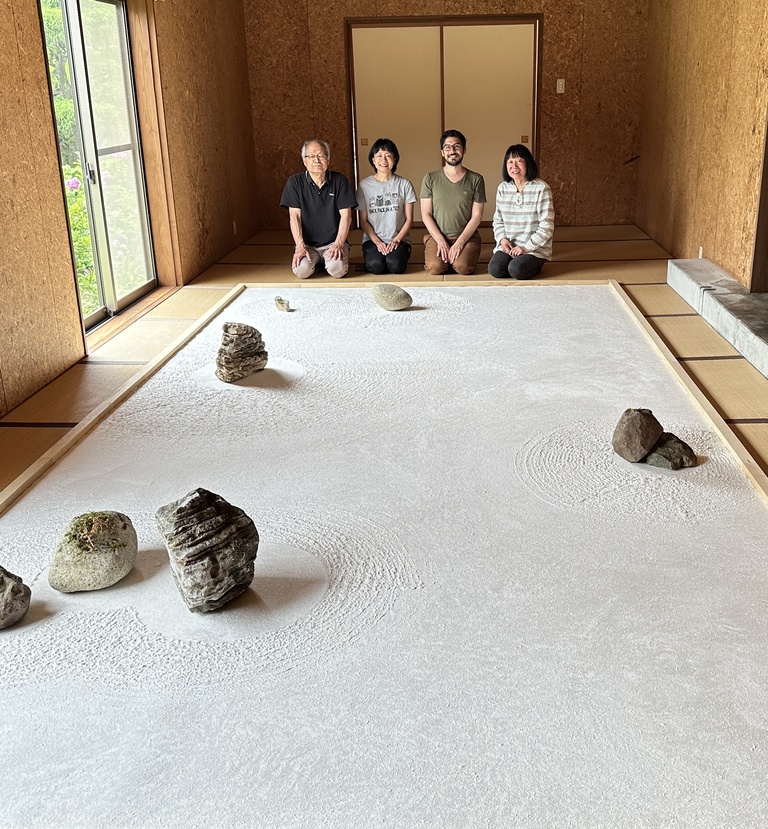 4 people sit behind a large papermaking installation