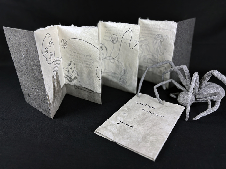 an accodion book of handmade paper with an ombre effect from gray to white.