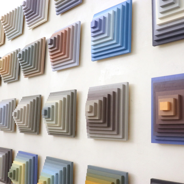 Nested squares of different colors displayed on a wall