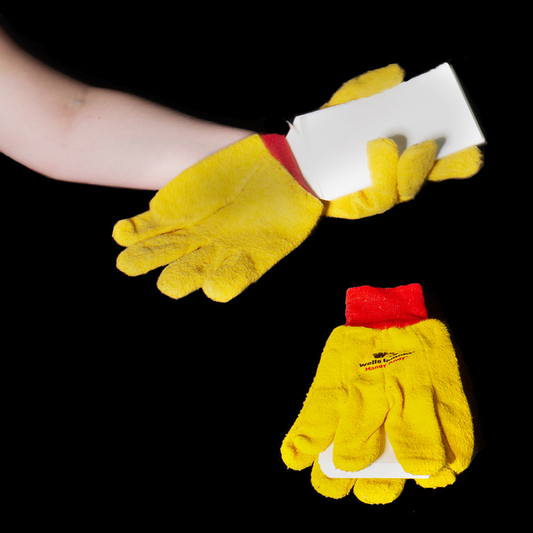 Hand holding a book enclosed in gloves
