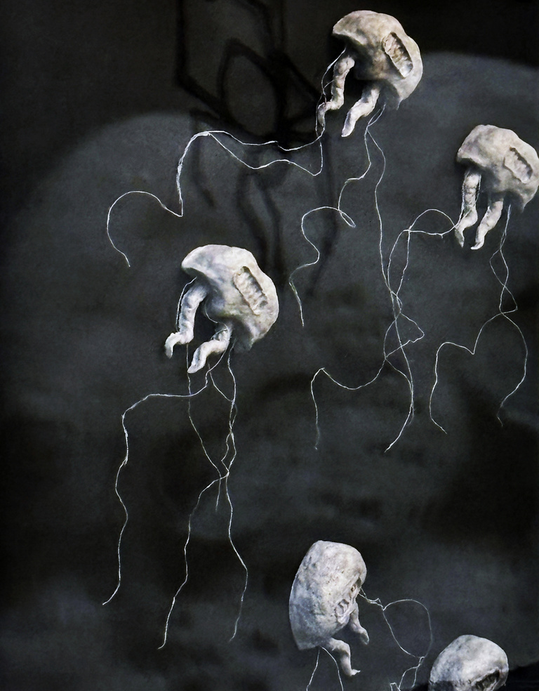 Scary creatures made of paper hung on a black background
