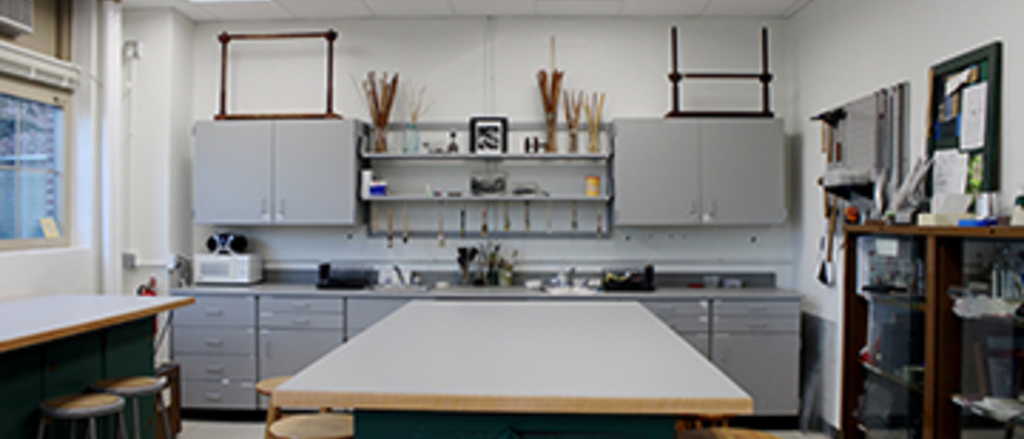 Kolarik Binding studio: one large table in the middle of the room with a counter and cabinests in the background