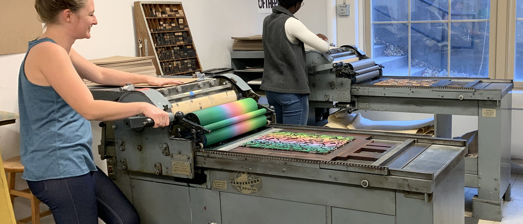 Two people print on two vandercook proof presses