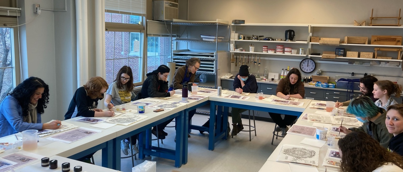 Students in a classroom painting with watercolors