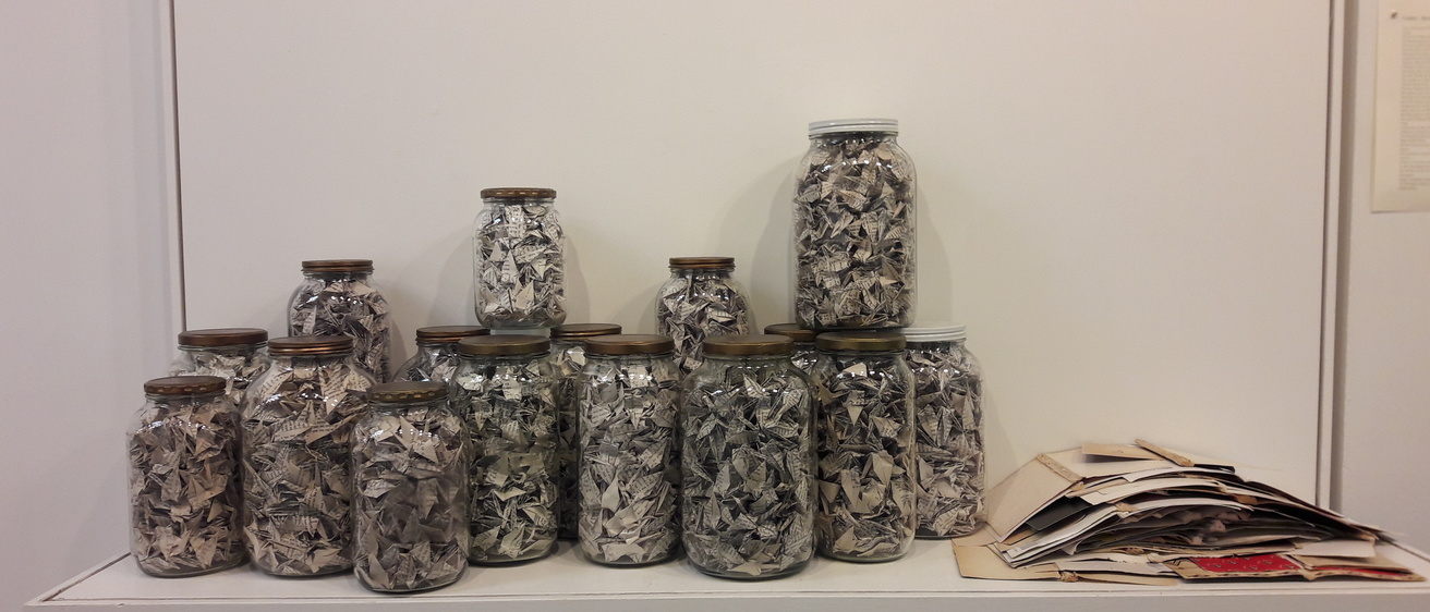 Photo of a new exhibit in the Merker Gallery showing glass jars filled with paper cranes. 
