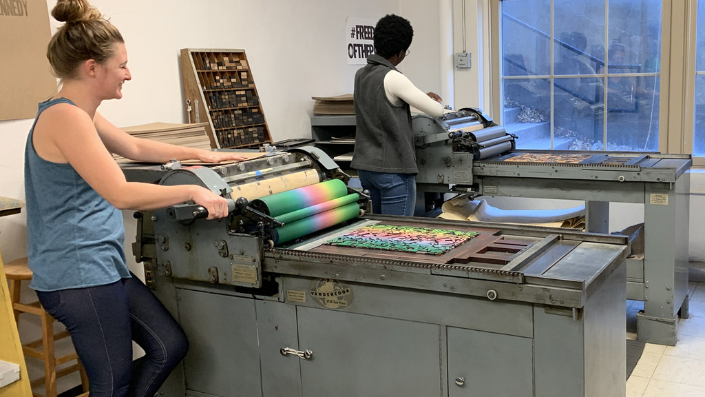Two people print on two vandercook proof presses
