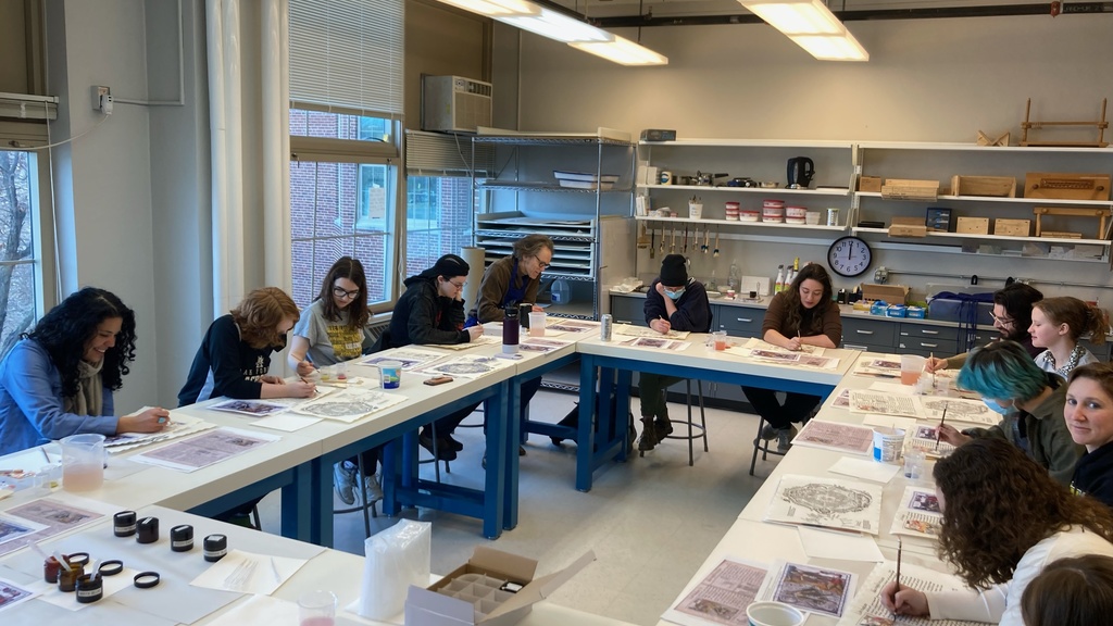 Students in a classroom painting with watercolors